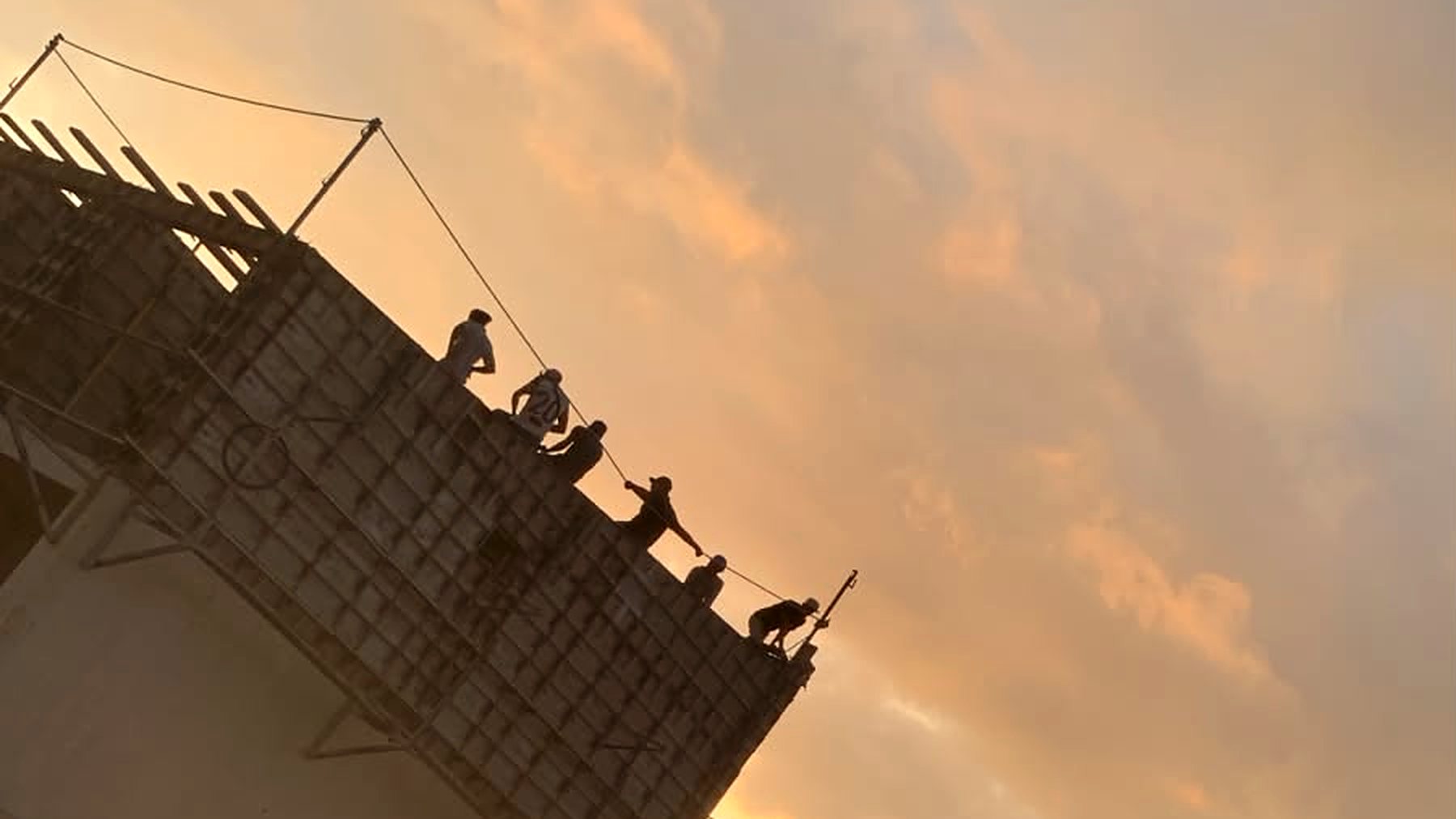 Trabajadores sobre el encofrado al atardecer